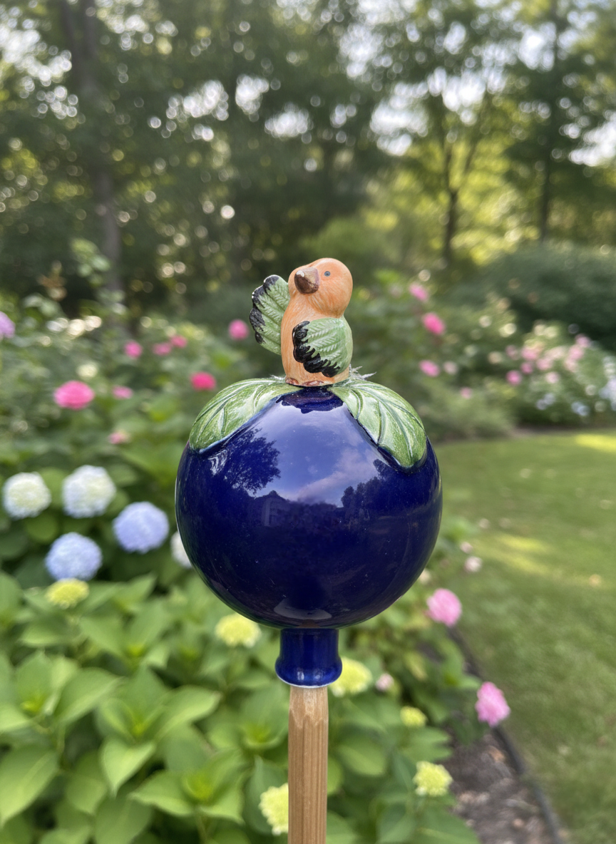 Dunkelblaue Gartenkugel aus Keramik mit orange-grünem Vogel | Balkon & Garten